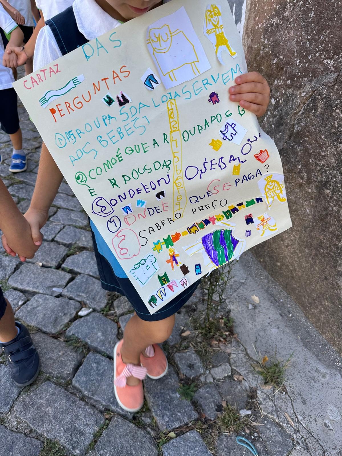 Criança com o cartaz das perguntas preparado pelo grupo