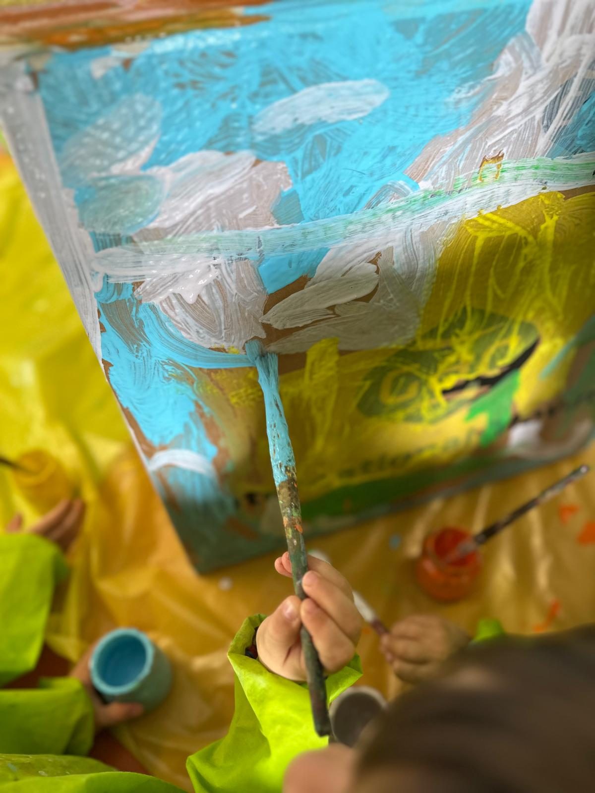 Criança a pintar um painel colorido